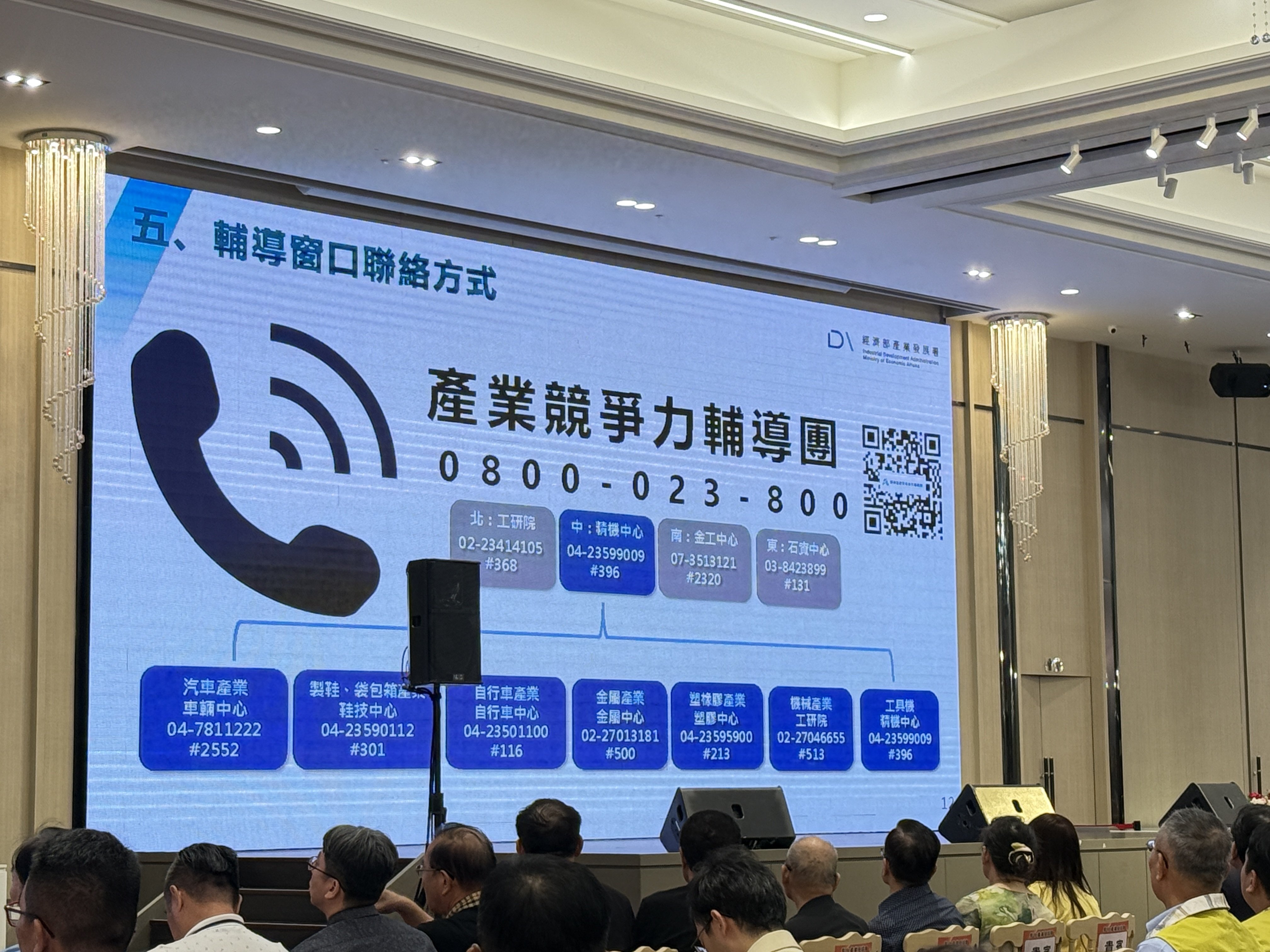彰化縣傳統產業經濟座談會現場，講者發言，背景螢幕顯示智慧製造及產業轉型的關鍵字。